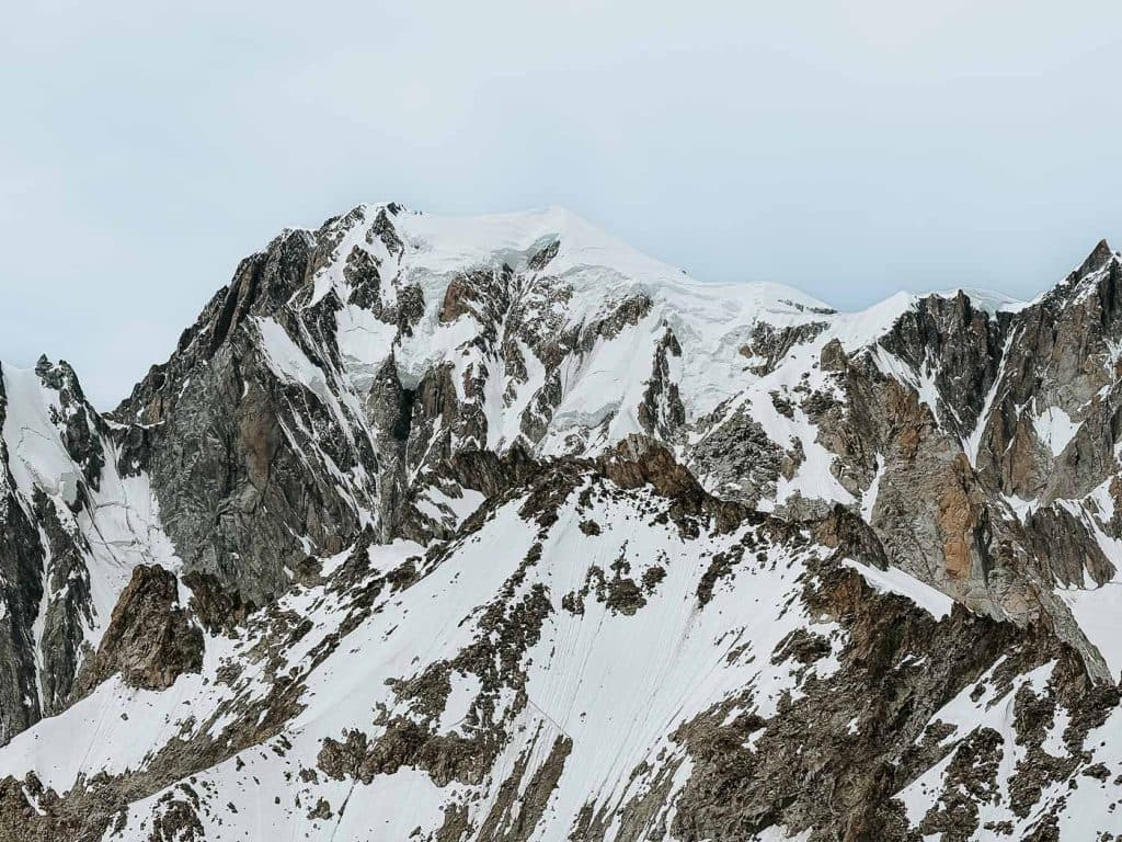 Besneeuwde rotsachtige bergtoppen onder een bewolkte hemel in Valle d'Aosta, met grillige bergkammen en stukken onbedekte rots die bijdragen aan de unieke Bergenmagie van de regio.