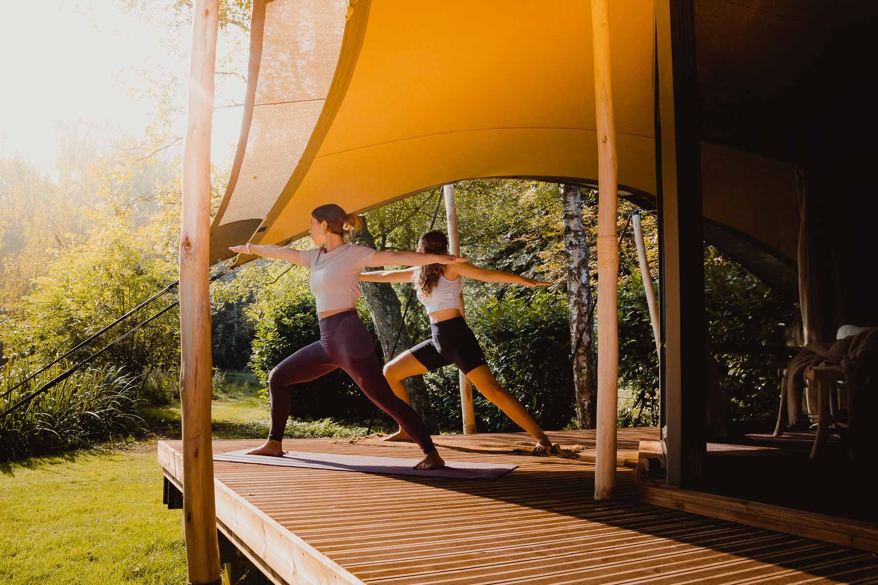 ochtendyoga op het houten dek van het tenthuis