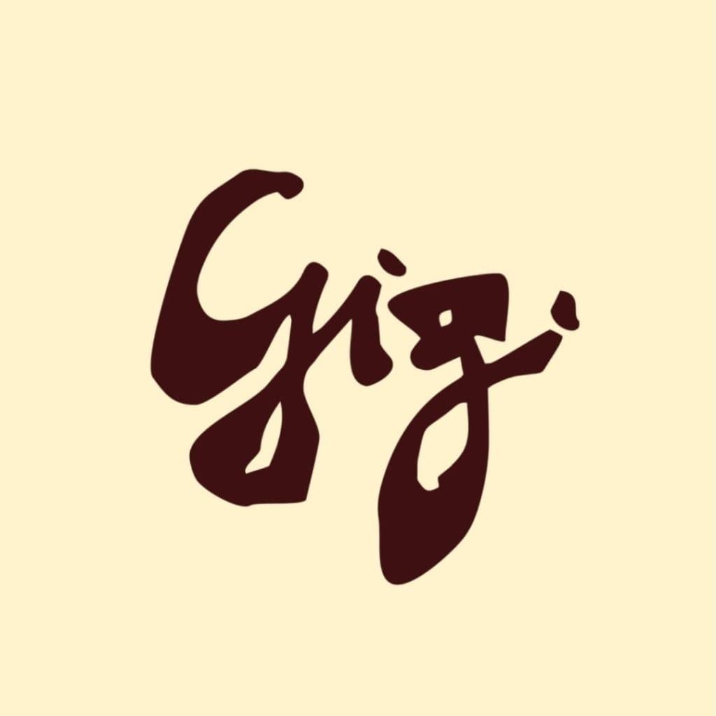 Het woord "Gig" is geschreven in een vet, bruin, penseelstreekachtig schrift op een lichtbeige achtergrond, wat de uitnodigende sfeer oproept van de beste restaurants van Hasselt.
