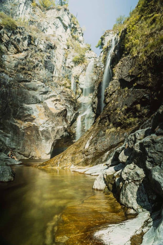 De Cascata del Salto valt in Maggia langs een rotswand van grijs graniet in een kom met groenig water.
